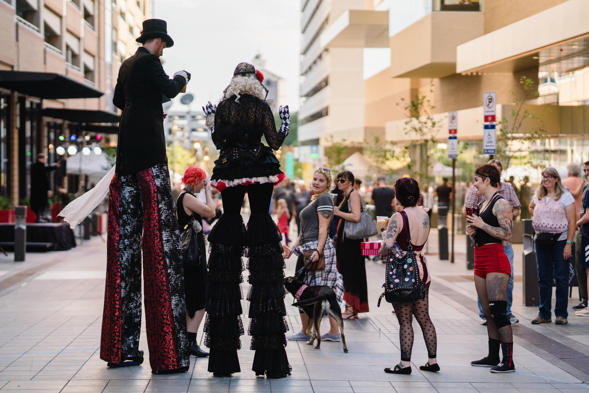 Two buskers/street performers on stilts interacting with the audience